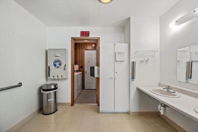 bathroom with washing machine and clothes dryer and sink