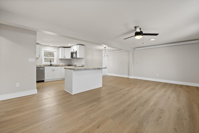 kitchen with ceiling fan, light stone countertops, decorative light fixtures, white cabinets, and appliances with stainless steel finishes