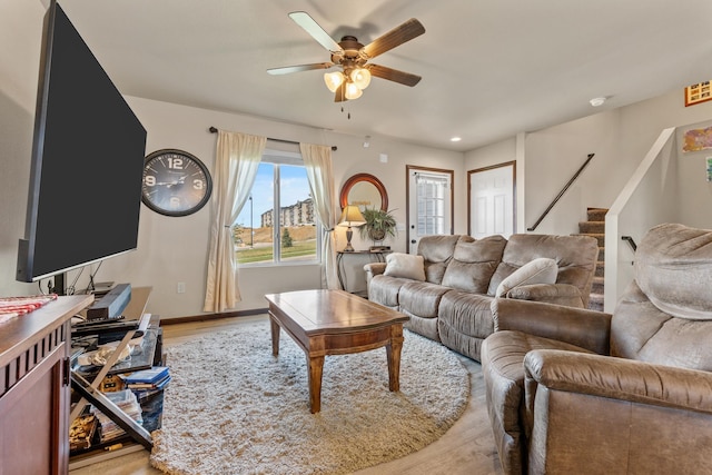 living room with ceiling fan and light hardwood / wood-style flooring