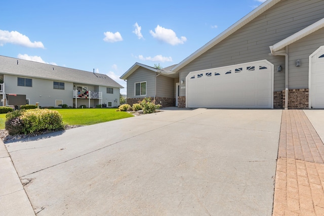 ranch-style home featuring a garage and a front lawn