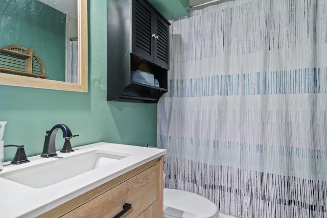 bathroom featuring vanity, toilet, and curtained shower