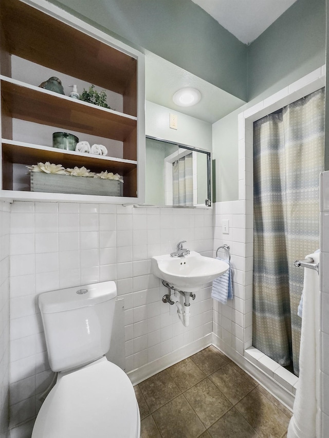 bathroom featuring tile patterned floors, tile walls, and toilet