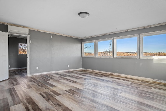 empty room with hardwood / wood-style floors and a wall unit AC