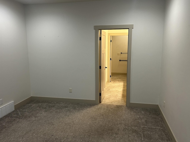 spare room with dark carpet