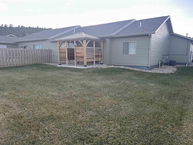 rear view of property with a gazebo and a yard