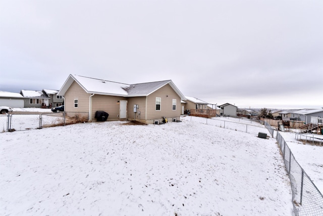 view of snow covered back of property