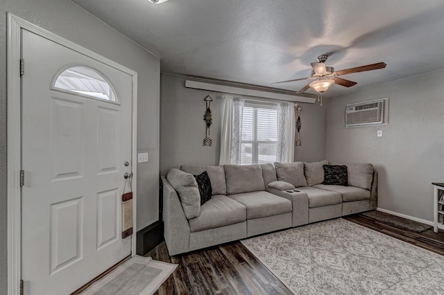 living room with a wall unit AC, ceiling fan, a textured ceiling, and dark hardwood / wood-style floors