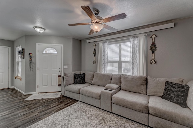 living room with ceiling fan, dark hardwood / wood-style flooring, and a textured ceiling