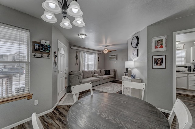 dining room with ceiling fan with notable chandelier and dark hardwood / wood-style floors