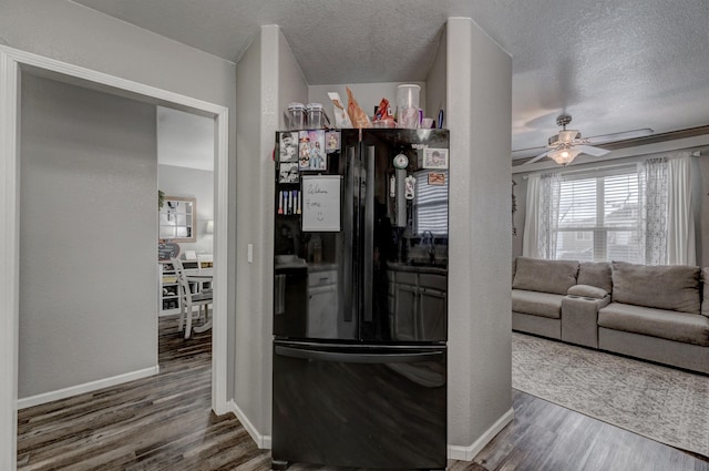 kitchen featuring black fridge, dark hardwood / wood-style flooring, ceiling fan, and a textured ceiling