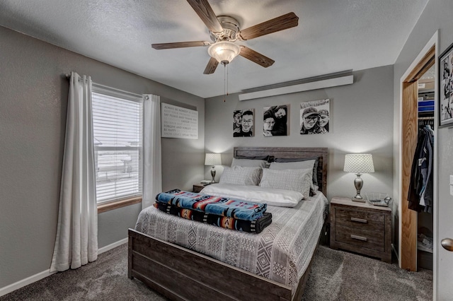 bedroom featuring a textured ceiling, dark carpet, and ceiling fan