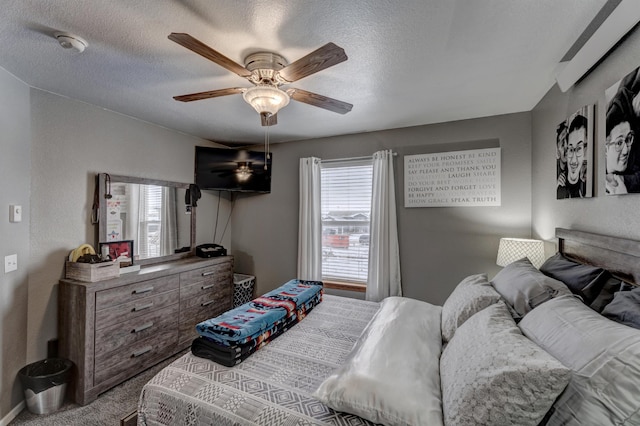 bedroom with ceiling fan, carpet, and a textured ceiling