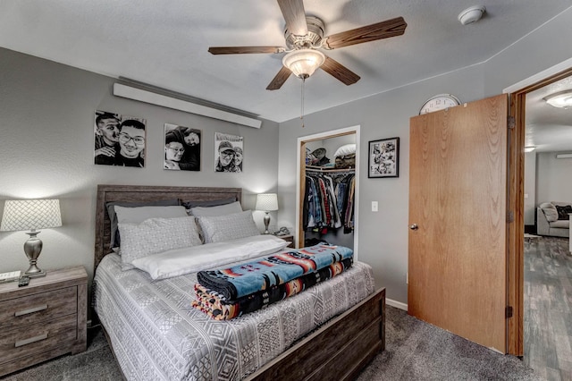 carpeted bedroom with ceiling fan, a spacious closet, and a closet