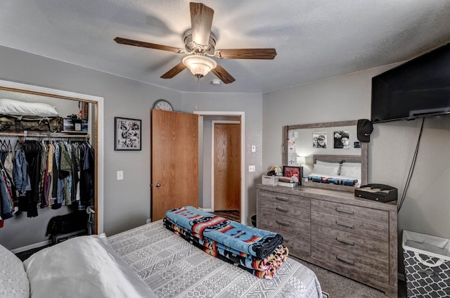 bedroom featuring carpet flooring, ceiling fan, a closet, and a textured ceiling