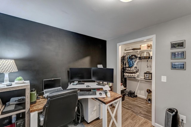 home office with light hardwood / wood-style flooring