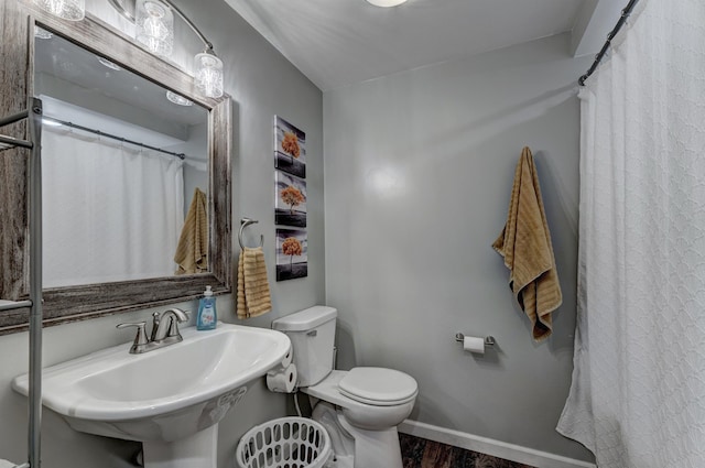 bathroom with hardwood / wood-style floors, toilet, and sink