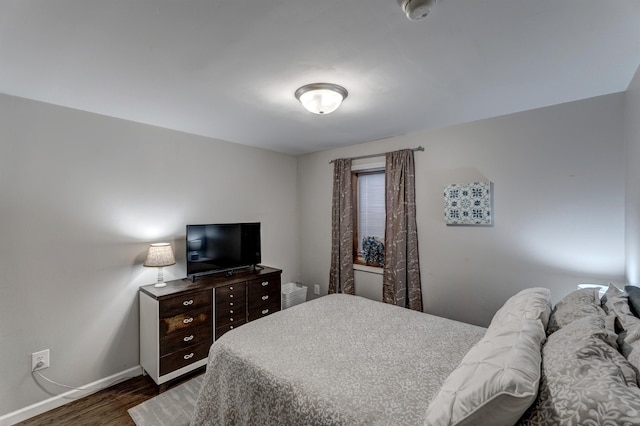 bedroom with dark hardwood / wood-style flooring