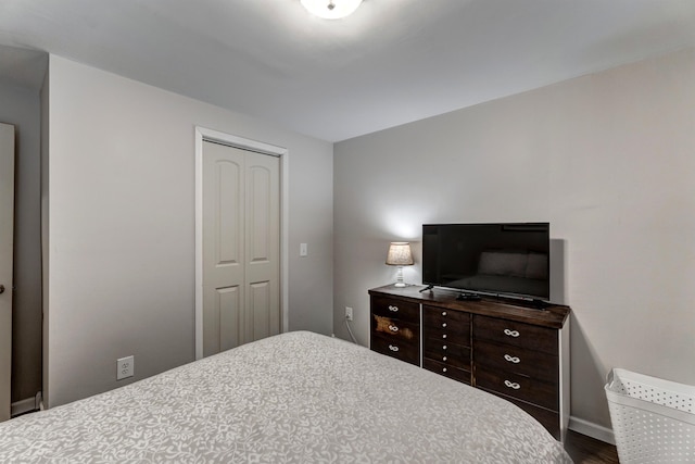 bedroom with a closet and dark hardwood / wood-style floors