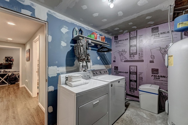 laundry room featuring light hardwood / wood-style flooring, washer and clothes dryer, and water heater