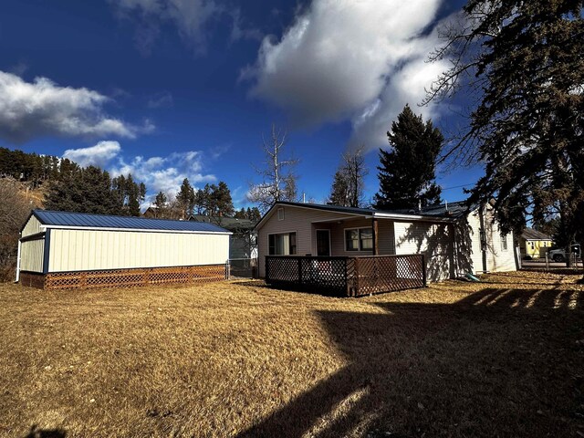 171 N Newton Ave, Hill City, SD 57745 - rear view of house featuring a lawn and a wooden deck