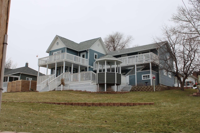 back of house with a balcony and a lawn