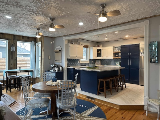 dining space with plenty of natural light, light hardwood / wood-style floors, and ceiling fan