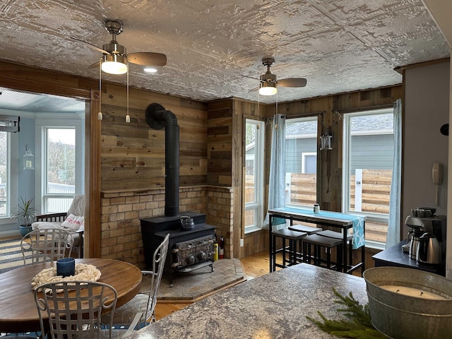 living room with hardwood / wood-style flooring, a wood stove, and ceiling fan