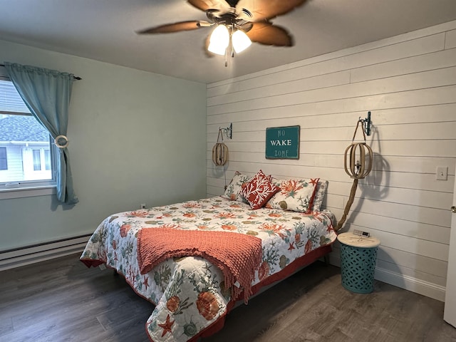 bedroom with ceiling fan, dark hardwood / wood-style flooring, wooden walls, and a baseboard heating unit