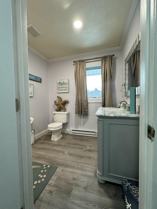 bathroom with hardwood / wood-style floors, vanity, crown molding, toilet, and baseboard heating