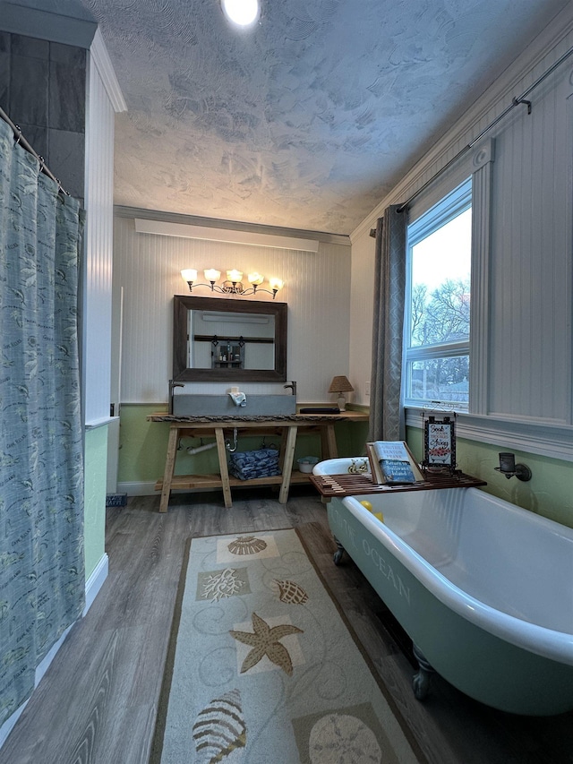 bathroom featuring wood-type flooring, a textured ceiling, and crown molding