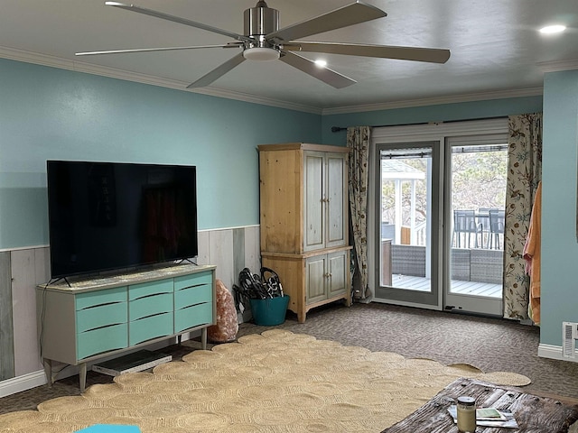 living room with wood walls, ceiling fan, and ornamental molding