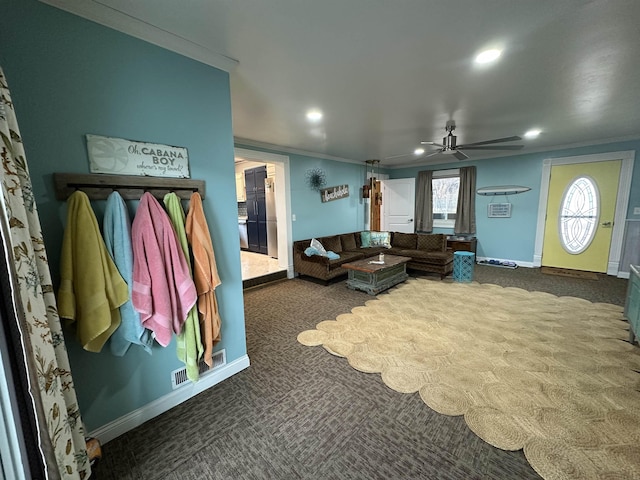 living room featuring ceiling fan, dark carpet, and ornamental molding