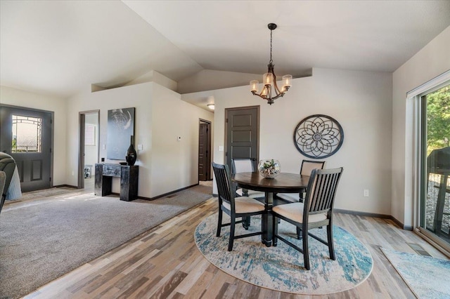 dining space featuring light wood-type flooring, lofted ceiling, and a notable chandelier