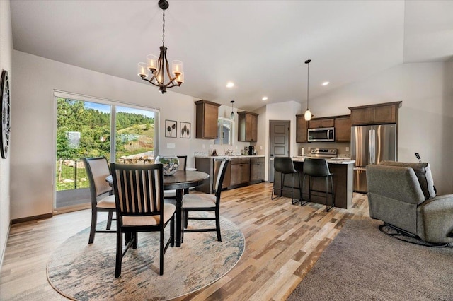 dining space with a chandelier, lofted ceiling, and light wood-type flooring