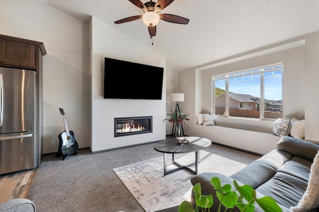 living room featuring ceiling fan, light carpet, and lofted ceiling