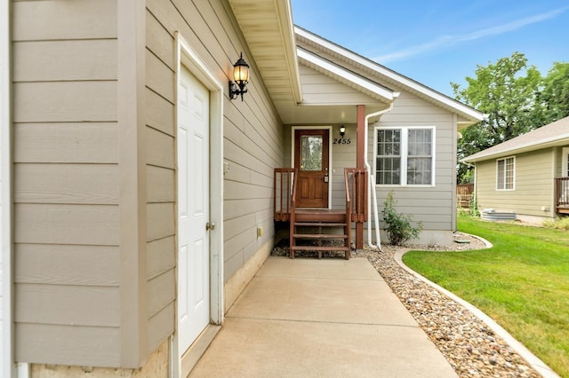 view of exterior entry featuring a lawn