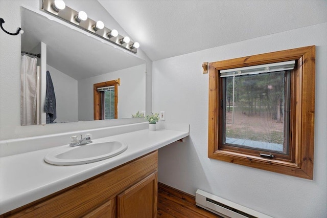 bathroom with a textured ceiling, vanity, vaulted ceiling, baseboard heating, and hardwood / wood-style flooring