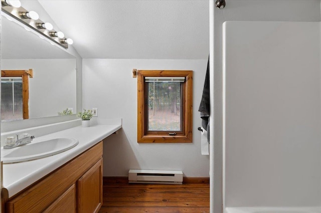 bathroom with vanity, hardwood / wood-style flooring, and a baseboard heating unit