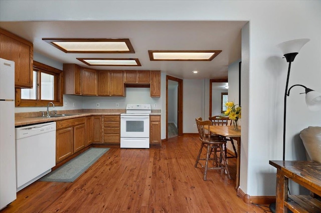 kitchen featuring light wood-type flooring, white appliances, and sink