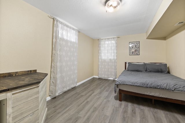 bedroom featuring hardwood / wood-style floors and a textured ceiling