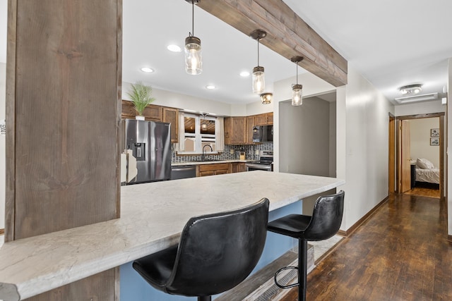 kitchen with sink, dark hardwood / wood-style floors, backsplash, kitchen peninsula, and appliances with stainless steel finishes