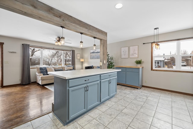 kitchen with decorative light fixtures, a center island, a wealth of natural light, and ceiling fan