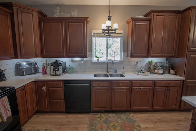 kitchen featuring black appliances, sink, decorative backsplash, light wood-type flooring, and a chandelier