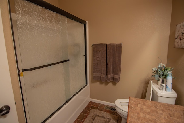 bathroom featuring tile patterned floors, toilet, and enclosed tub / shower combo