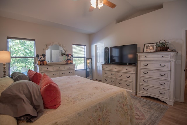 bedroom with ceiling fan, lofted ceiling, light wood-type flooring, and multiple windows