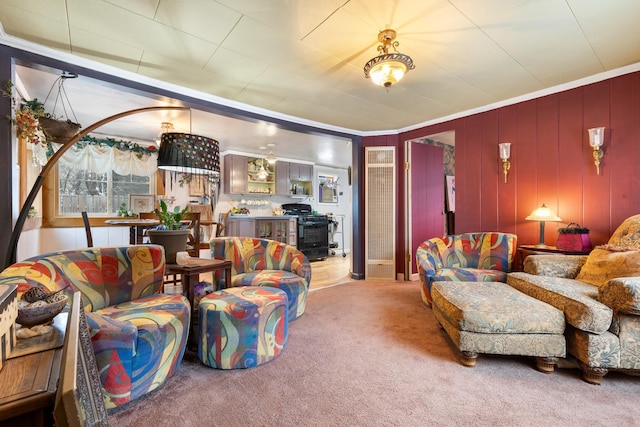 carpeted living room featuring ornamental molding and wood walls