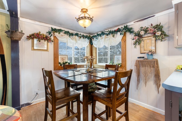 dining area with light hardwood / wood-style flooring and crown molding