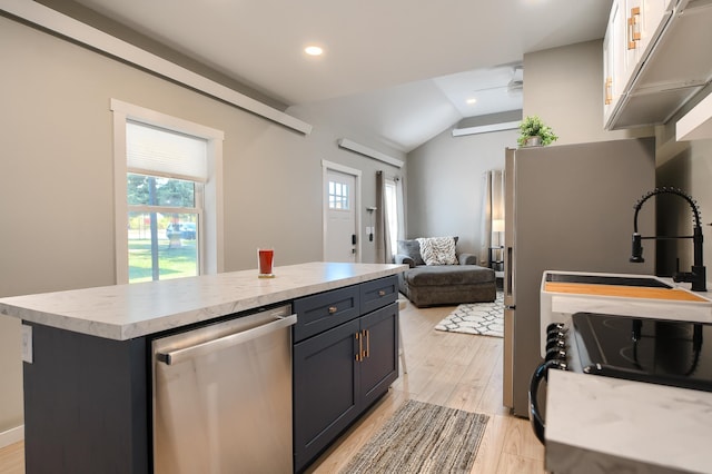 kitchen with a center island, white cabinetry, stainless steel dishwasher, and vaulted ceiling