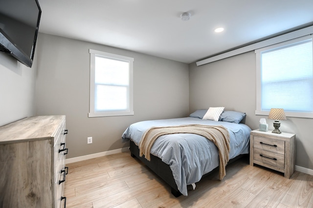 bedroom featuring multiple windows and light hardwood / wood-style flooring