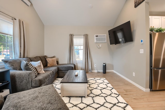 living room with lofted ceiling, light hardwood / wood-style flooring, and a wall mounted AC